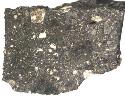 A chip from “Black Beauty,” a meteorite from Mars, contains different rock types welded together. It helps explain the Martian “dark plains,” large areas of the planet’s surface that have only a thin layer of red dust.