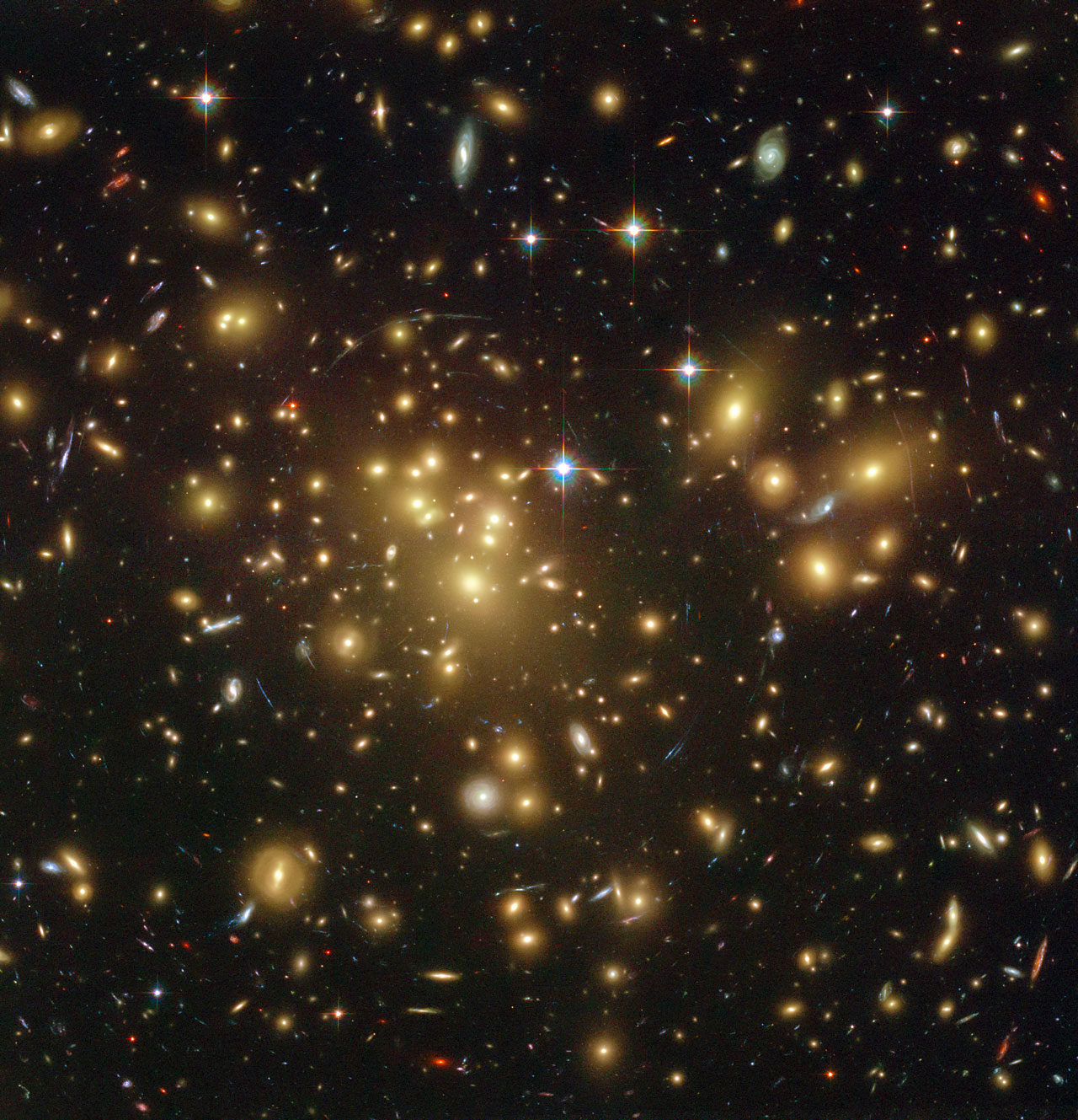 The distant dusty galaxy A1689-zD1 behind the galaxy cluster Abell 1689 (Credit: NASA; ESA; L. Bradley (Johns Hopkins University); R. Bouwens (University of California, Santa Cruz); H. Ford (Johns Hopkins University); and G. Illingworth (University of California, Santa Cruz)