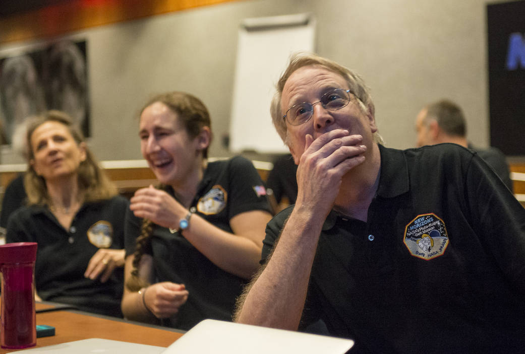 Members of the New Horizons science team react to seeing sharpest image of Pluto before closest approach. Photo Credit: (NASA/Bill Ingalls)