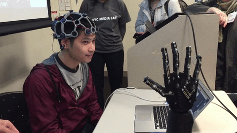 Man controlling a robotic arm with brain waves using BCI. Credit: OpenBCI