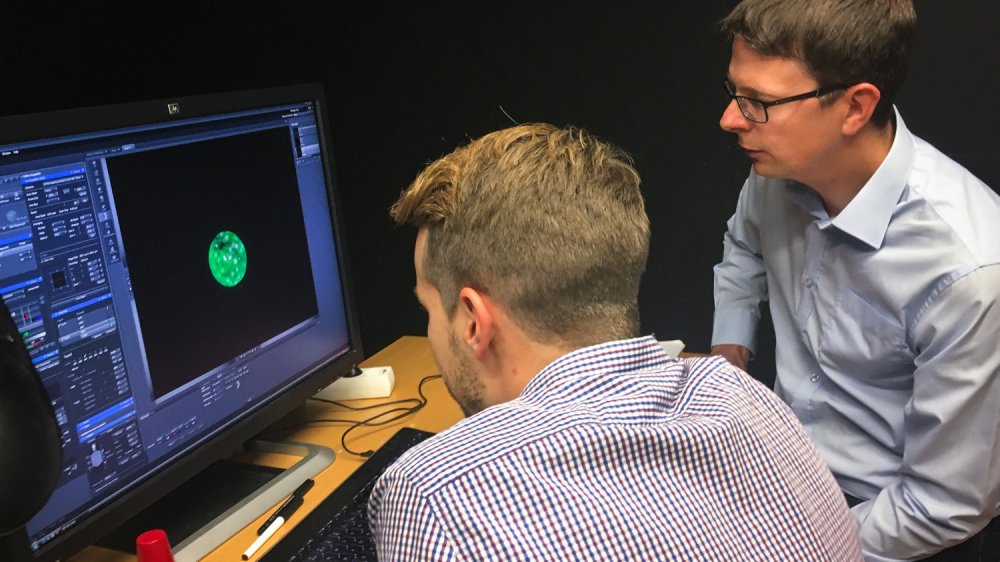 Fredrik Lanner (right) and his student study a magnified human embryo. Image by Rob Stein/NPR