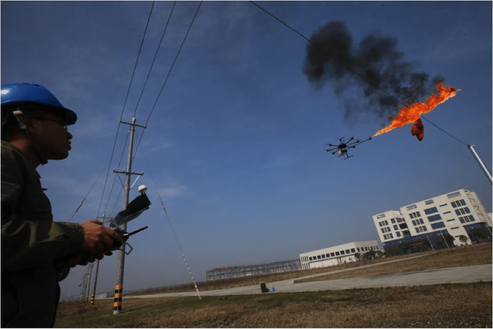 Electric company maintenance workers utilizing the drone flamethrower to clean electrical wires that have garbage attached to them. Photo by Wang Hu/VCG