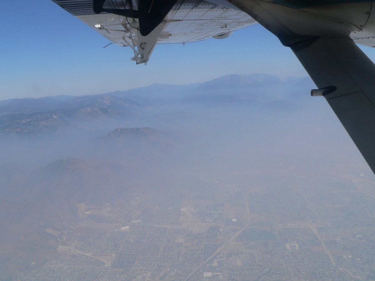 Air pollution in the form of smog over the city and hills of Los Angeles, as seen from within an airplane.