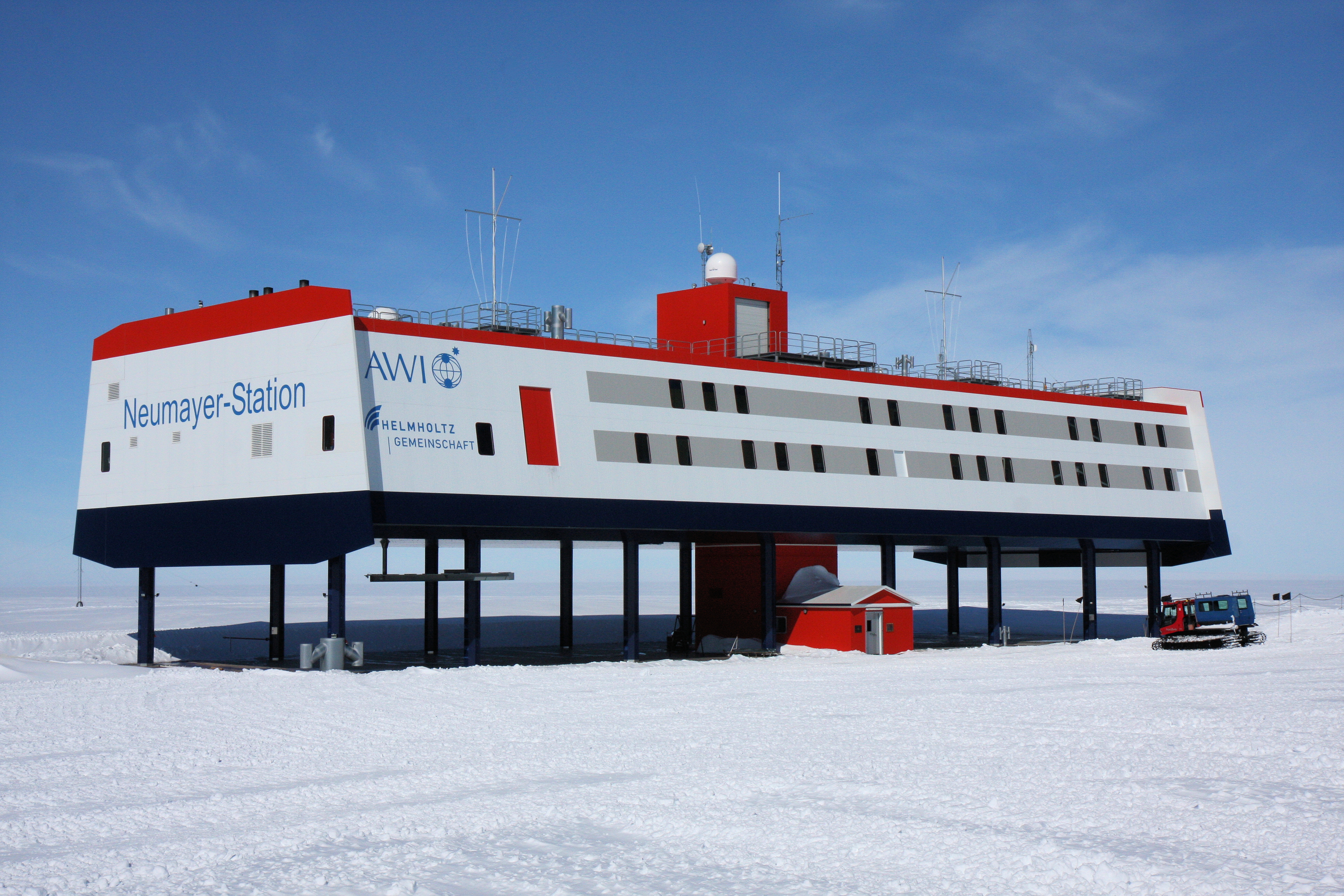Neumayer Station III, where the vegetables are growing: a long, rectangular station in red, white and gray set on poles above the ice.