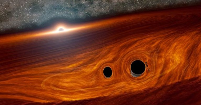 Researchers found an incredibly rare explosion that they think was caused by two black holes merging while orbiting an even larger one.