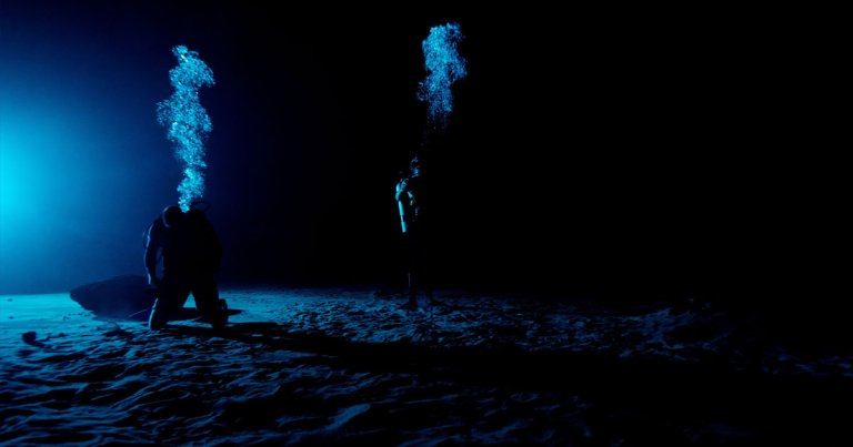 Divers at the NASA Neutral Buoyancy Laboratory set the stage for Artemis I training by simulating the Moon's lighting conditions in a cold, dark pool.