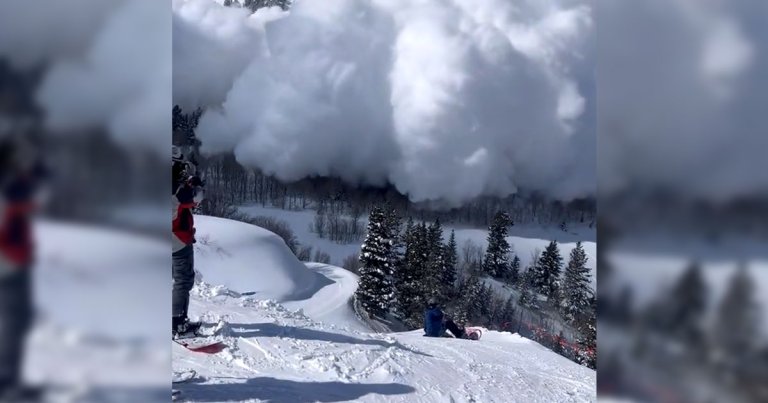 An amazing video recorded by Thoams Farley shows a couple of skiers watching as a giant avalanche thunders through a snowy mountain valley.