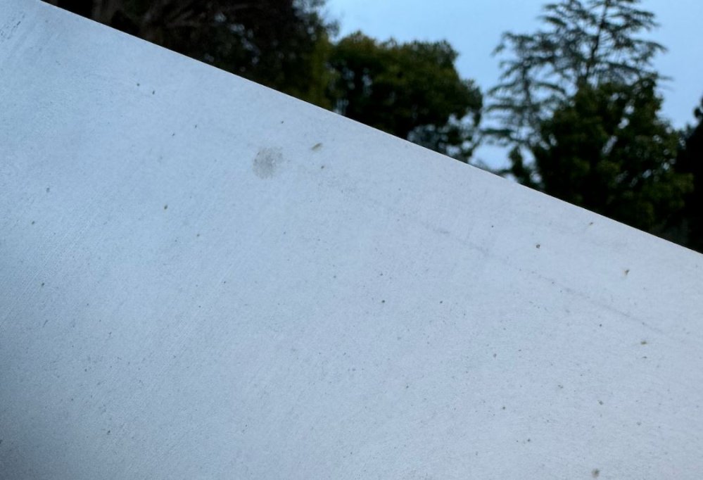 A Cybertruck body panel pockmarked with small orange spots