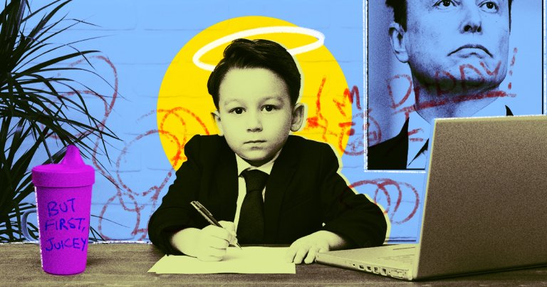 A young boy in a black suit sits at a desk, with paperwork, a laptop, and sippy cup.