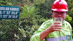 Harita Nickel Director of health, safety, and environment, stands with a container of water to his lips at a photo-op at the Kawasi Spring on the Indonesian island of Obi.
