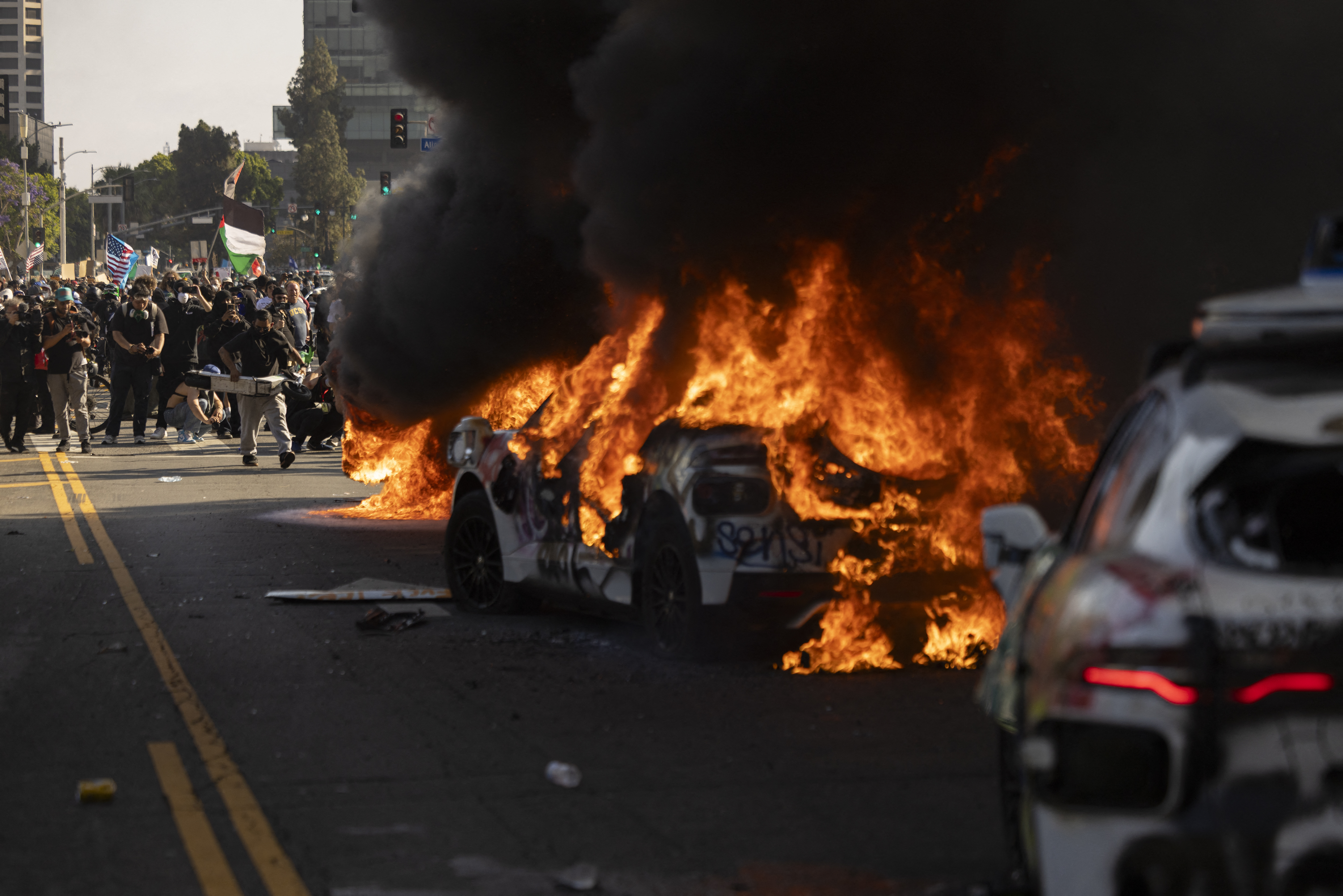 A photo shows numerous Waymo taxis wrecked and burning during the LA riots