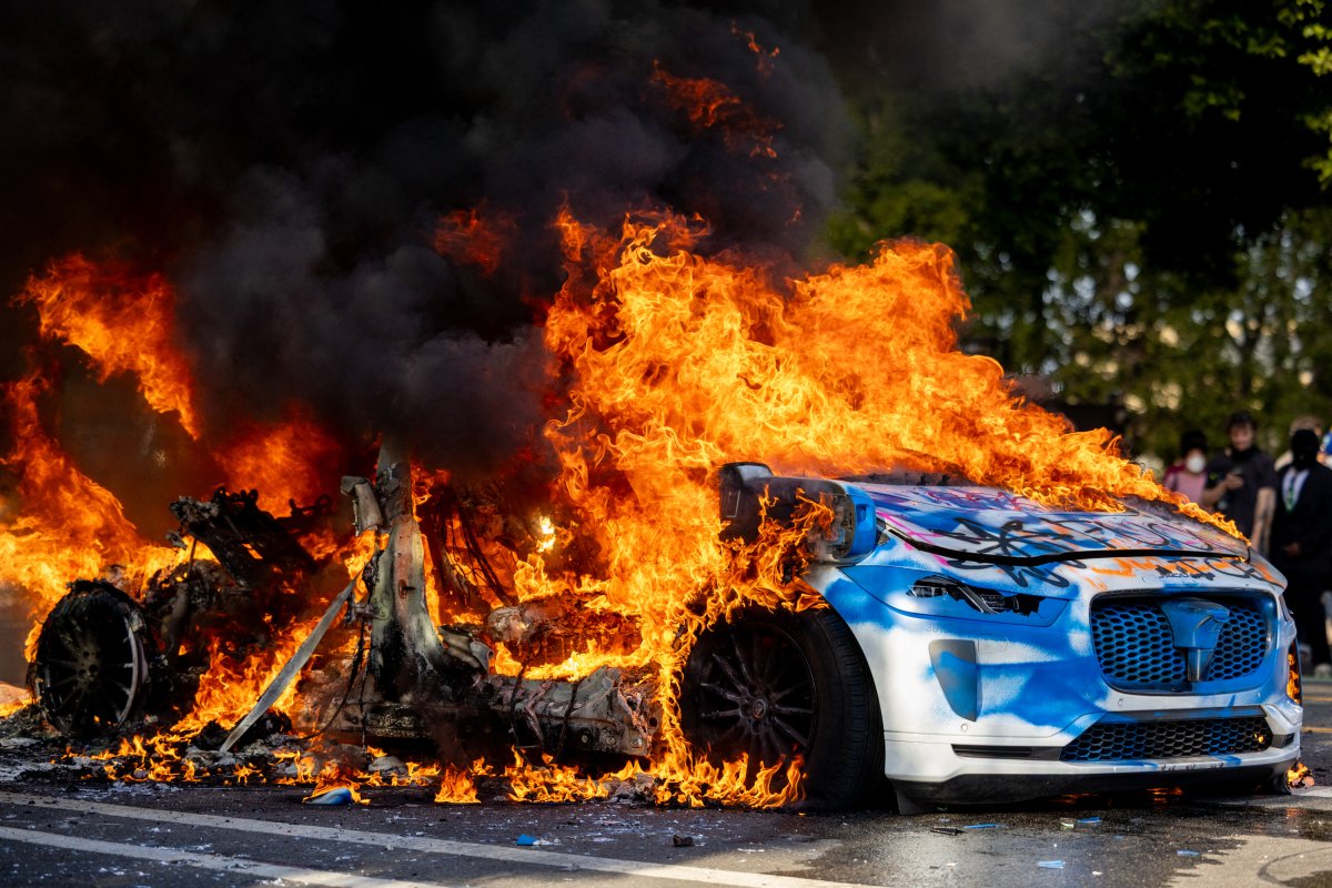 A Waymo self-driving taxi is seen in flames during the LA riots