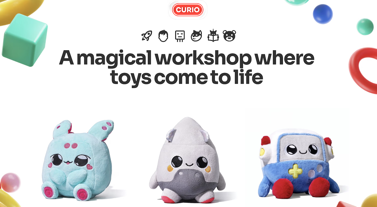 In the top center, a red curved rectangle with white font reads the word "Curio." Beneath it, the words "A magical workshop where toys come to life," and beneath that, three stuffed toys — one powder blue with raspberry spots (left), one grey and conical (center), and one blue and off-white shaped roughly like a calculator (right). 