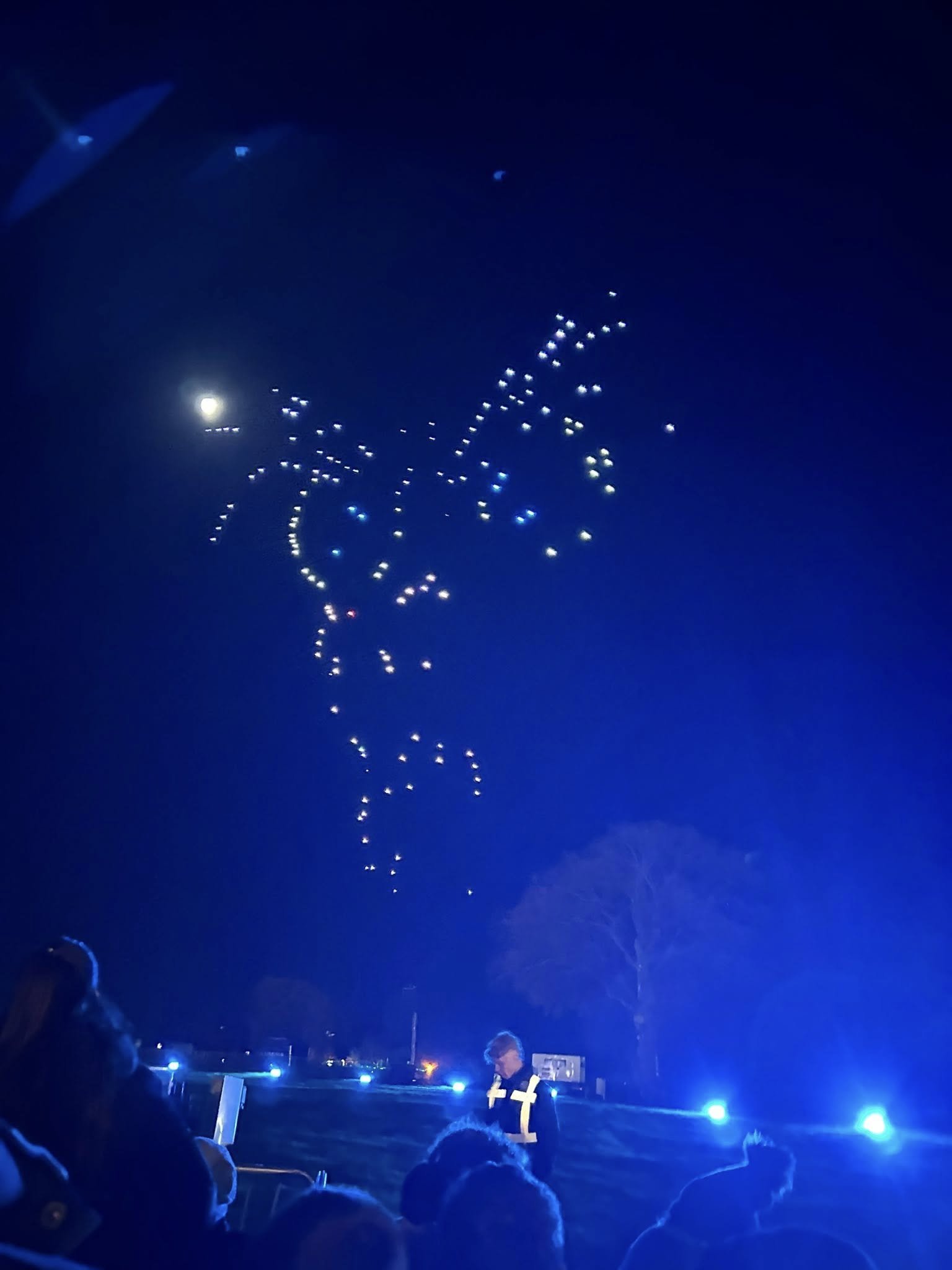 A few LED drones against a bright blue light make up a confusing holiday display, with obvious gaps in the image.