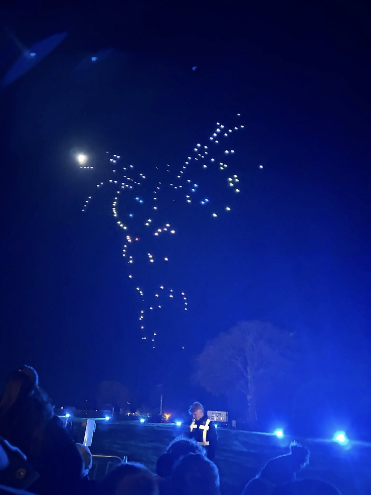 A few LED drones against a bright blue light make up a confusing holiday display, with obvious gaps in the image.