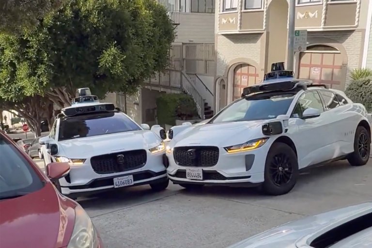 Two Waymo robotaxis crashed into each other in a dead-end street, blocking traffic while a third Waymo watches on.