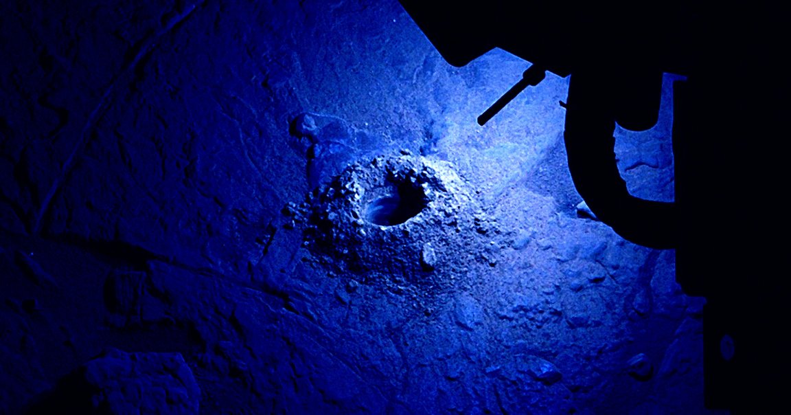 An image taken by NASA's Curiosity rover shows its LED lights lighting up a hole it drilled into the surface of the rock.