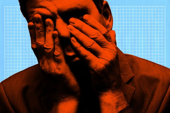 A close-up of a person with their face covered by both hands, showing a distressed or contemplative expression. The image is stylized with an orange overlay on the person and a light blue background featuring a white grid pattern. The person is wearing a suit jacket.