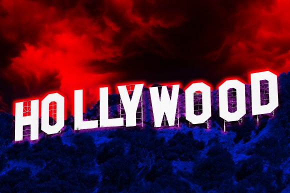 The Hollywood sign on a hillside with an intense color effect: the sky is glowing red with dark clouds, and the hillside is shaded in deep blue and purple tones. The white letters of the sign have a red glow around them.