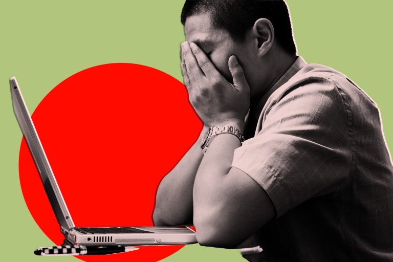 A man sitting at a desk with a laptop in front of him, covering his face with both hands, appearing stressed or overwhelmed. The background features a large red circle on a light green backdrop. The man is wearing a short-sleeved shirt and a wristwatch.