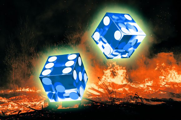 Two large, glowing blue dice with white dots float above a blazing fire in a dark outdoor setting. The dice emit a greenish light, contrasting with the intense orange flames and dark background.