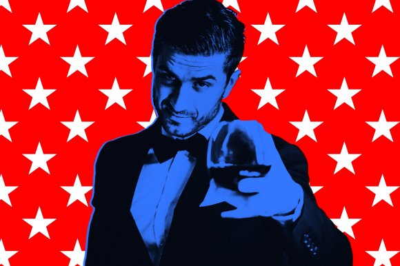 A man in a tuxedo with a bow tie, tinted blue, is holding a glass of dark liquid towards the camera. The background is bright red with a repeating pattern of white stars.