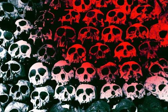 A dense arrangement of human skulls stacked closely together, with the upper half of the image tinted red and the lower half in a pale white or grayish tone, creating a stark contrast. The skulls are detailed, showing eye sockets, nasal cavities, and teeth, with some appearing more worn or damaged than others. The background is dark, emphasizing the skulls' shapes and colors.