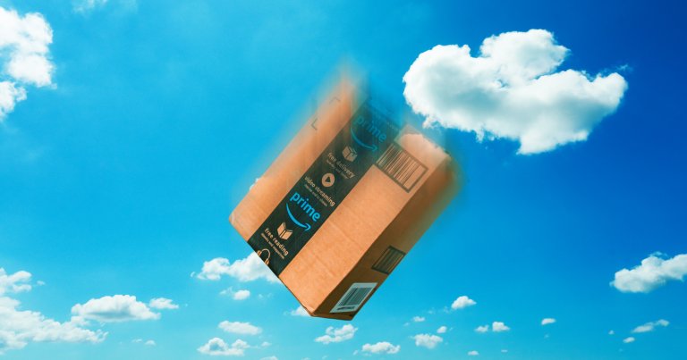 A cardboard Amazon Prime package is shown falling through a bright blue sky with scattered white clouds. The package appears slightly blurred, indicating motion.