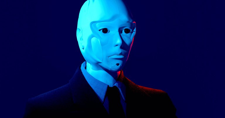 A humanoid robot with a smooth, pale blue face and black eyes, dressed in a dark suit, shirt, and tie, set against a deep blue background with subtle red lighting on one side of the face.