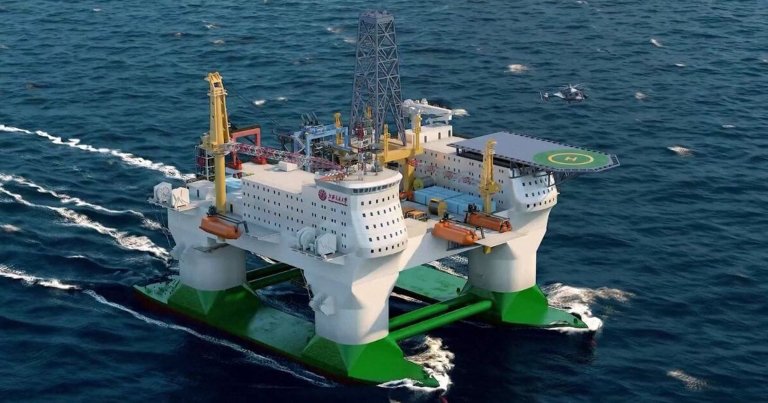 A large offshore oil rig platform with a green and white base floating on the ocean. The platform has multiple structures, including two main white buildings with numerous windows, yellow cranes, and a helipad marked with an "H" on the right side. A helicopter is flying nearby over the water. The rig is surrounded by deep blue ocean waves.
