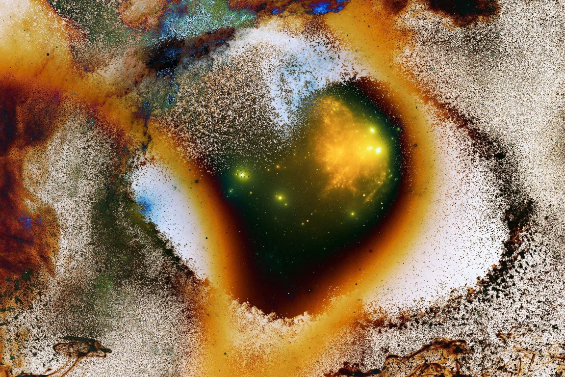 A vibrant, abstract image featuring a central heart-shaped area with a glowing yellow and green core surrounded by a gradient of dark brown, orange, and white speckled textures. The surrounding areas have a mix of blue, green, and brown hues with a grainy, scattered pattern that gives a cosmic or nebula-like appearance.