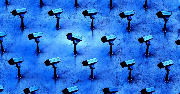 Multiple security cameras mounted on a textured blue wall, arranged in a grid pattern, all facing in roughly the same direction.