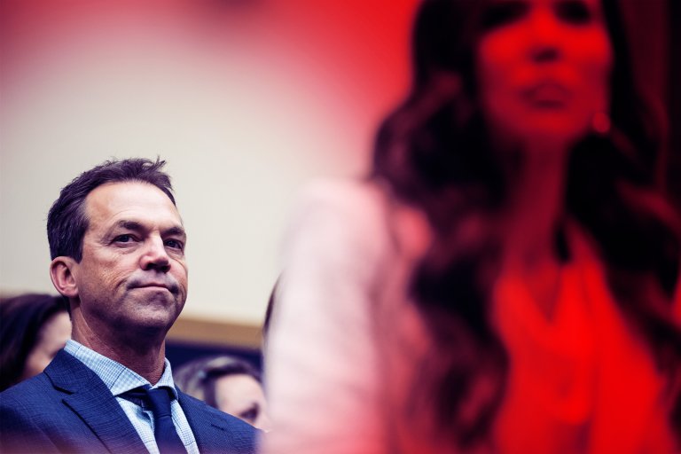 Bryon and Kristi Noem are shown with a blurred background. The setting appears to be indoors, possibly at an event or meeting.