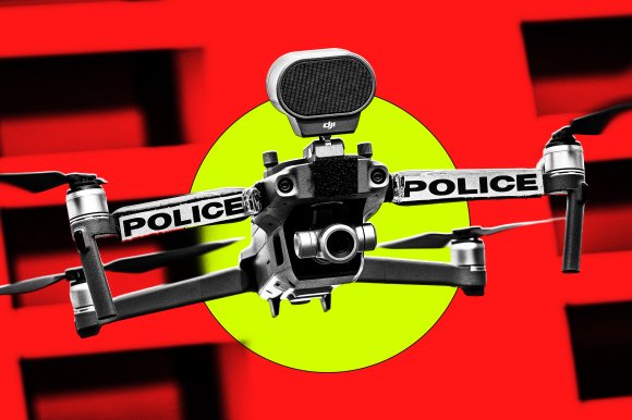 Black and gray police drone with four propellers and a camera mounted on the front, set against a bright red background with a yellow circle behind it. The word "POLICE" is printed in bold black letters on white strips attached to the drone's arms.