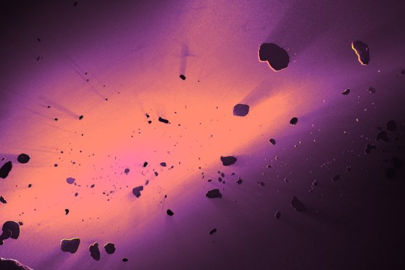 A vibrant cosmic scene featuring a glowing, bright orange and pink nebula or energy cloud at the center, surrounded by numerous dark, irregularly shaped asteroids or space debris scattered throughout a purple-hued space background. The light from the nebula casts subtle highlights on some of the nearby asteroids.