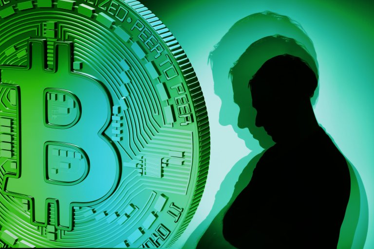 A large green and blue Bitcoin symbol on the left side, with a silhouette of a person on the right side casting multiple shadows against a green background. The image conveys a digital or cryptocurrency theme.