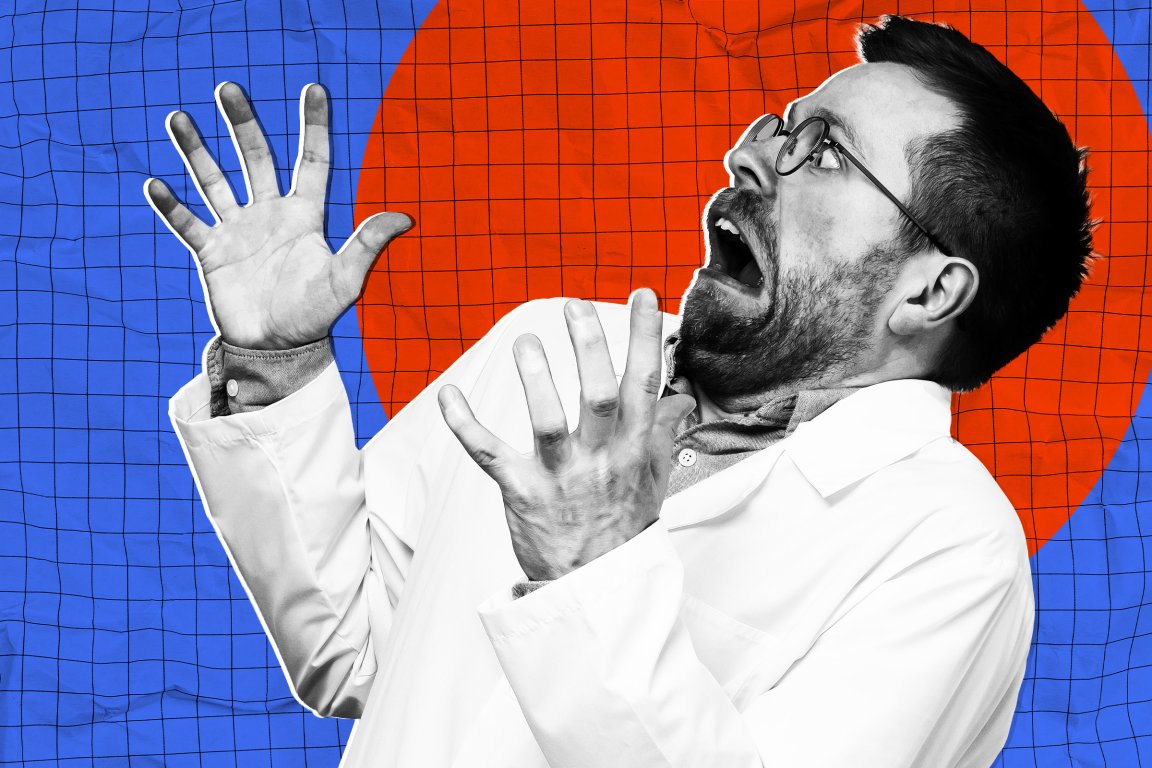Man in a white lab coat and glasses with a beard, appearing shocked or scared, with hands raised and mouth open. The background features a blue grid pattern with a large red circle.