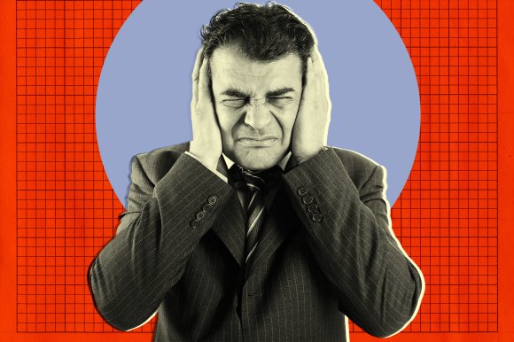 A man in a pinstripe suit and tie is covering his ears with both hands, eyes tightly shut, and displaying a pained or distressed expression. The background features a large blue circle centered on a red grid pattern. The image has a stylized, high-contrast look with a slight outline around the man.