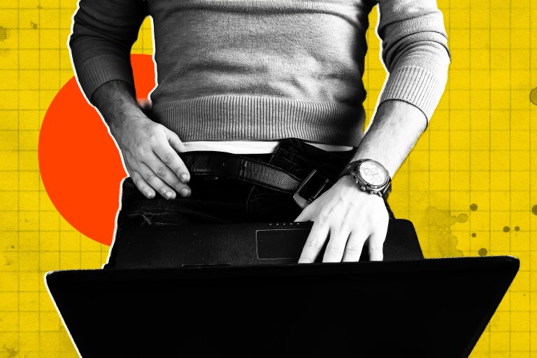 A man reclines with a computer on his lap and one hand pulling at his belt.