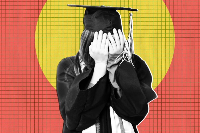 A person wearing a black graduation cap and gown is covering their face with both hands. The background features a red grid pattern with a large yellow circle behind the person.