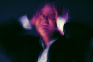 A person is shown clutching their head in distress.