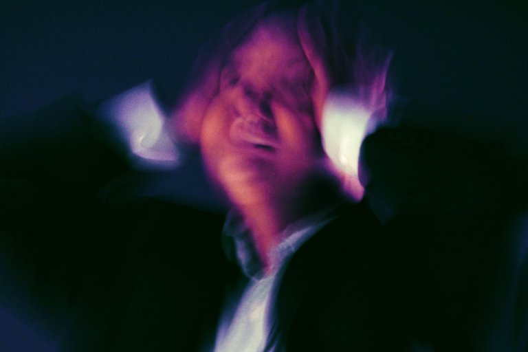 A person is shown clutching their head in distress.