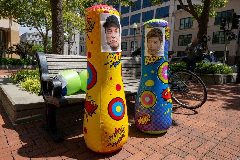 Inflatable punching bags with added pictures of Elon Musk and Sam Altman are seen outside the Ronald V. Dellums Federal Building and US Courthouse as the Musk v. Altman trial begins in Oakland, California, on April 27, 2026.