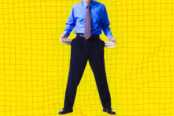 A businessman in a blue shirt and tie turns his empty pockets out in a gesture of being broke.