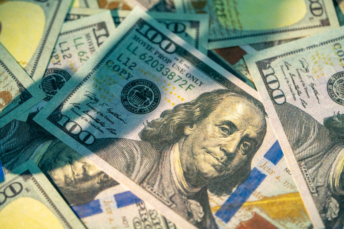 Several U.S. $100 bills are shown, with the prominent portrait of Benjamin Franklin.
