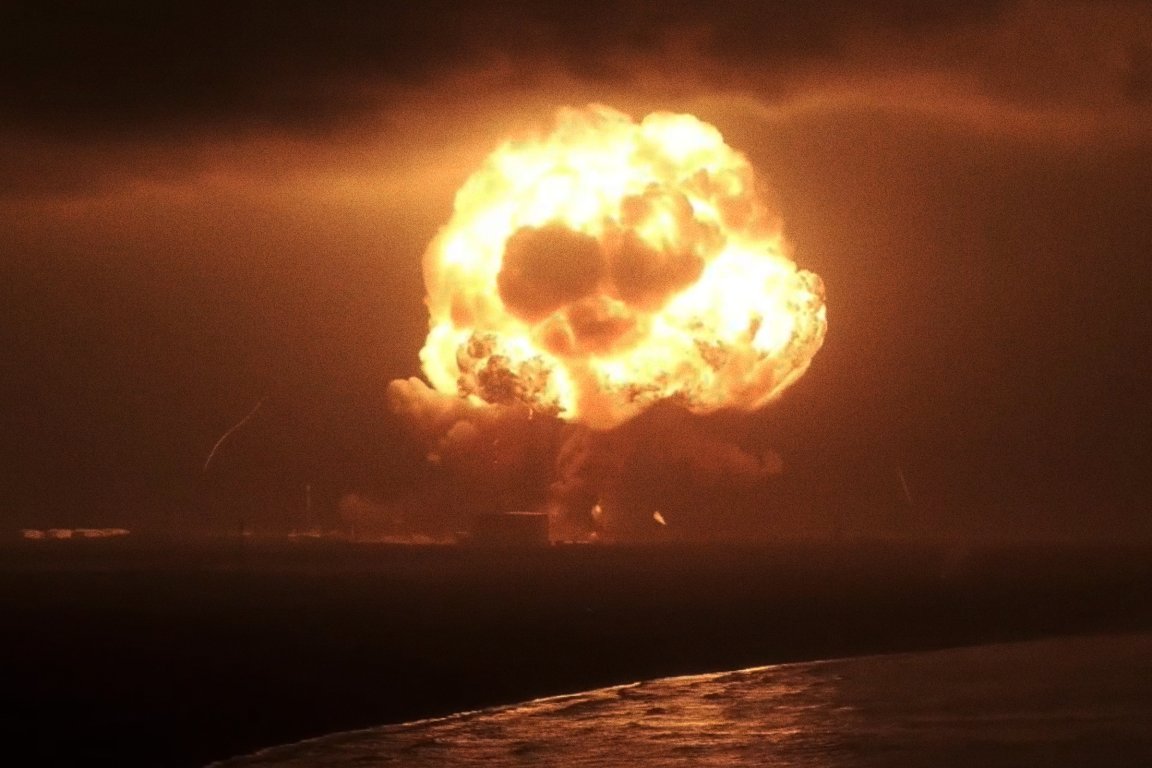 A large mushroom cloud plumes in the night sky.