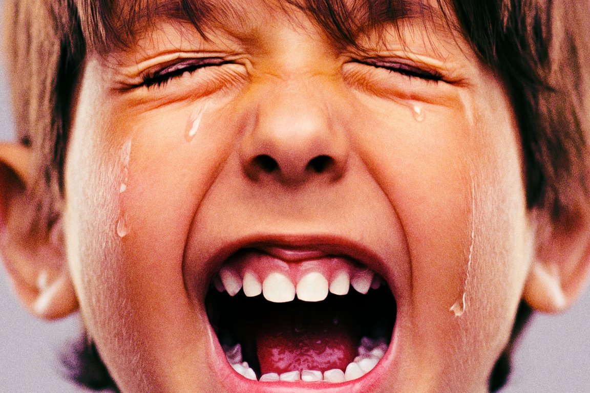 Close-up photograph of a young boy crying and screaming.
