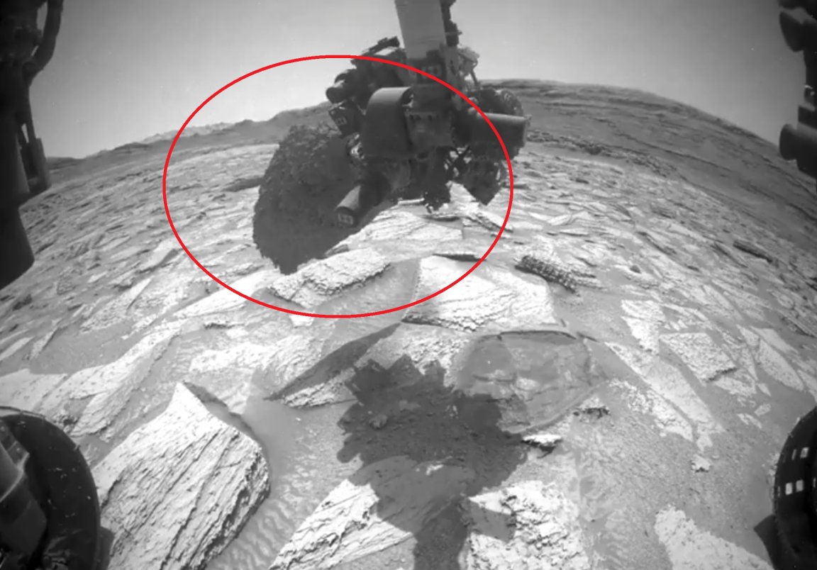 The image shows a robotic arm on NASA's Curiosity Mars rover that has become stuck inside a rock on the Red Planet.