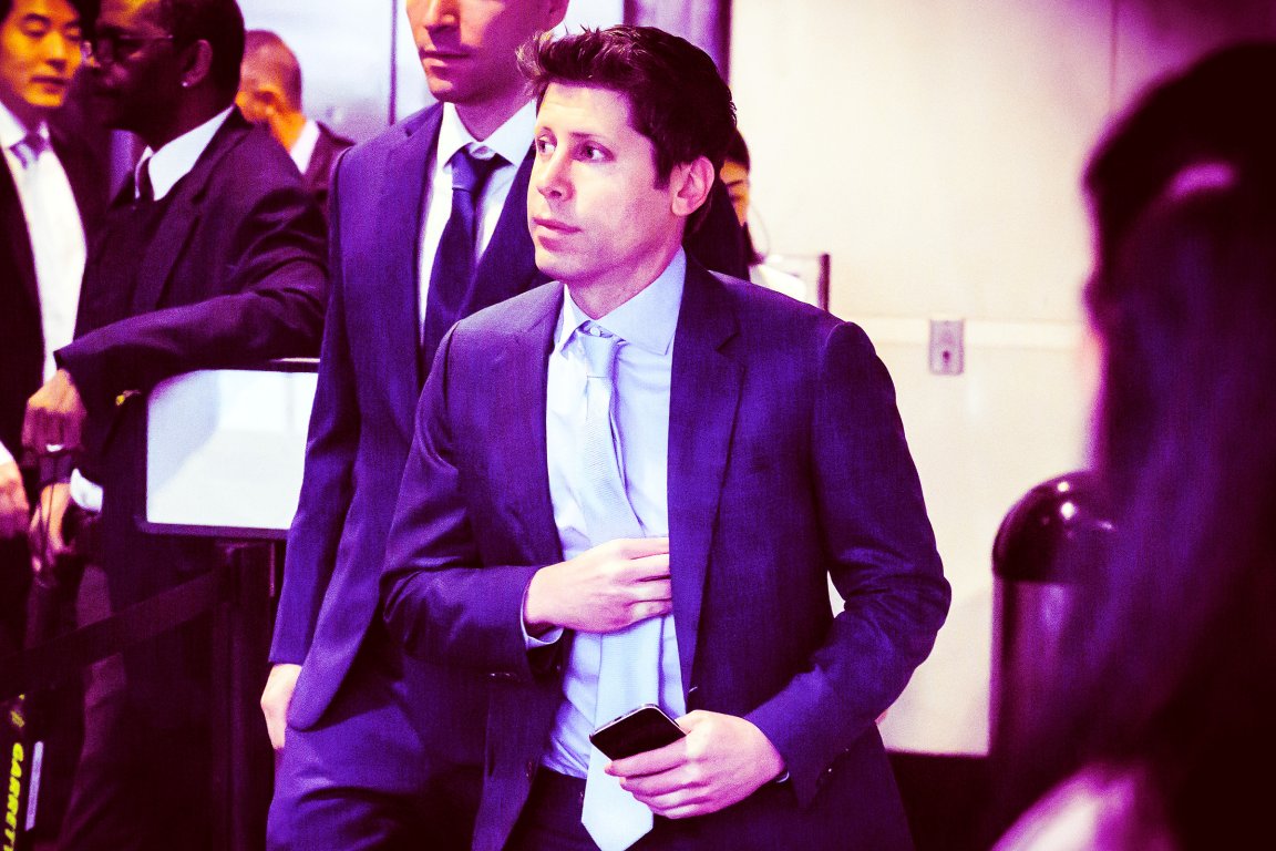 OpenAI CEO Sam Altman is shown in a light blue shirt and matching tie, holding a smartphone in his right hand and adjusting his jacket with his left hand.