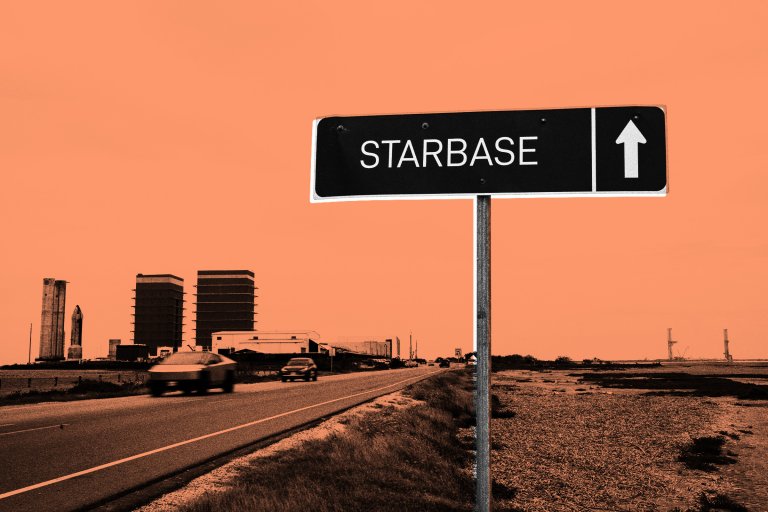 A road sign with the word "STARBASE" and an upward-pointing arrow is positioned beside a highway. In the background, there are industrial buildings and structures, including two large, rectangular buildings and a rocket-like structure. The sky has an orange tint.